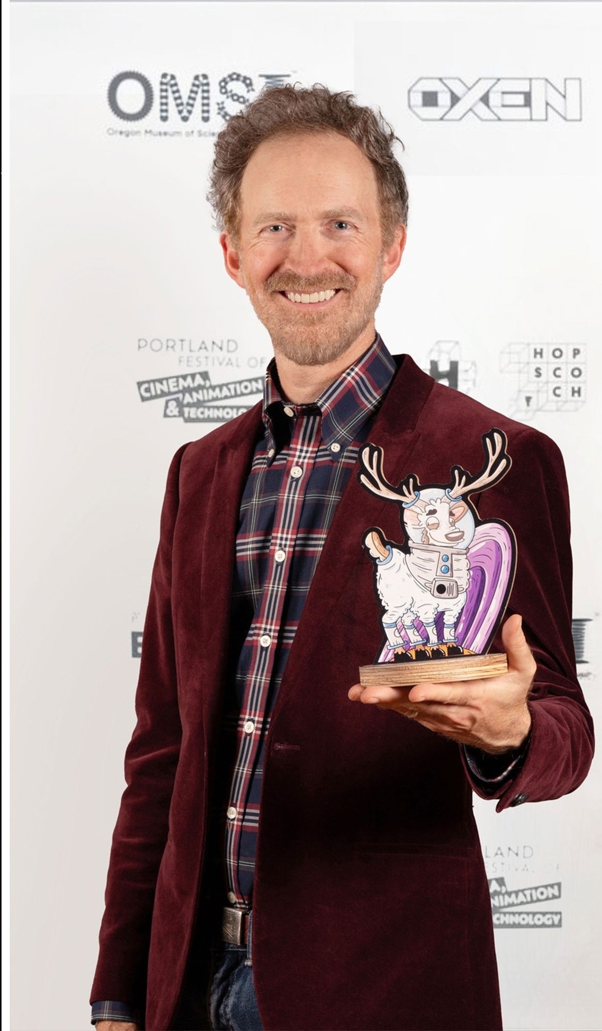 Gavin Farrell holding the Best Narrative Film trophy at the Portland Festival of Cinema, Animation & Technology, for The Earth Above