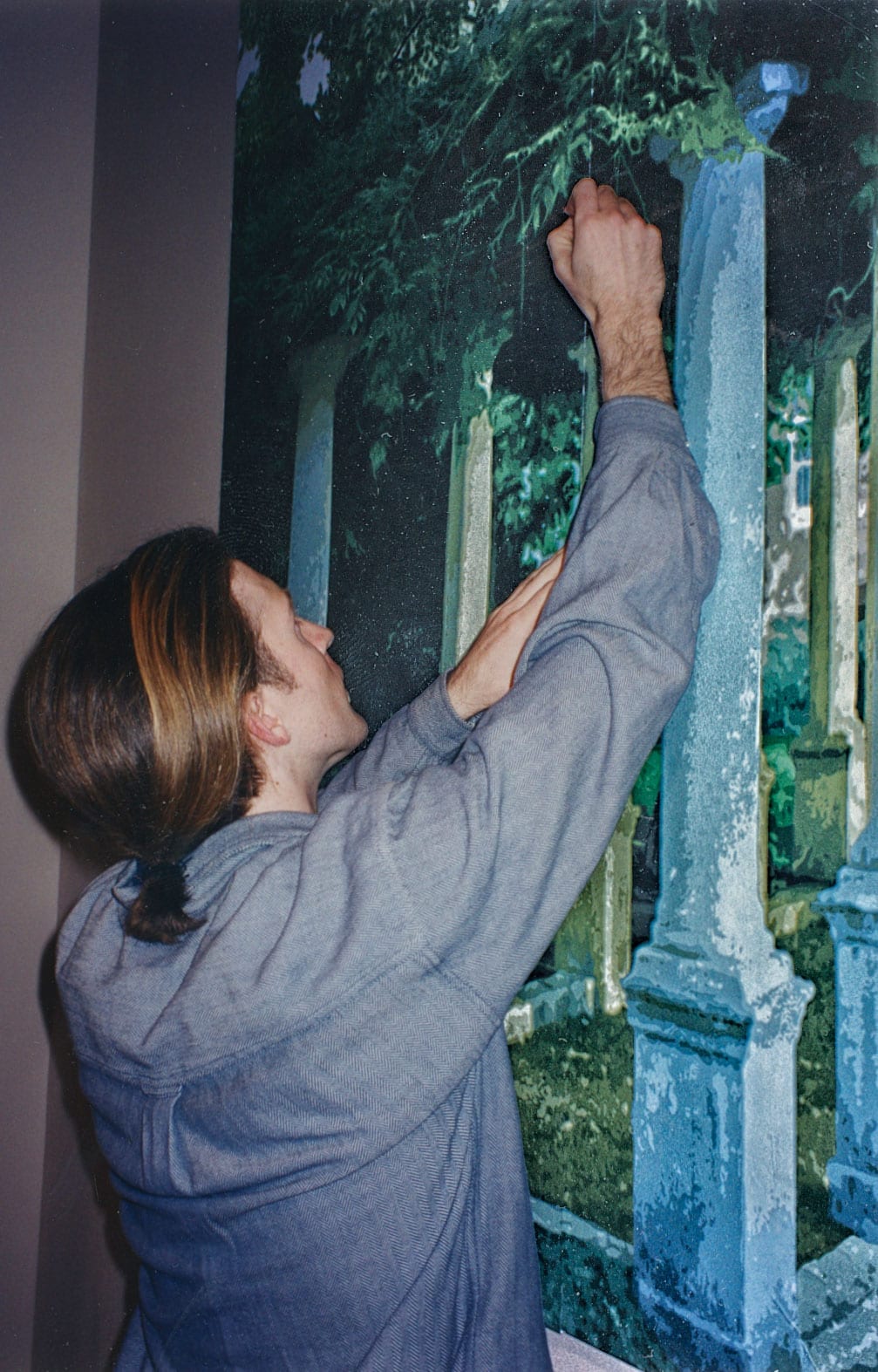 Gavin reaching up to work on the painted cemetery scene of the Bank of Rhode Island mural
