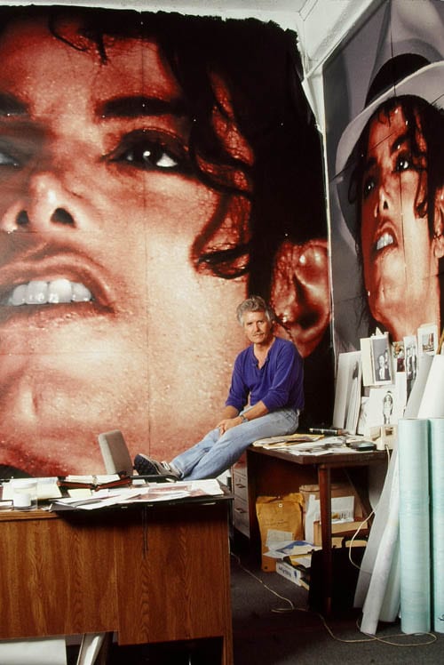 Kent Twitchell seated in his studio in front of large-scale panels of the in-progress Michael Jackson mural