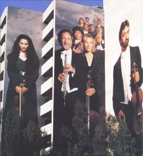 Detail view of the Harbor Freeway Overture mural, showing three musician panels against a downtown Los Angeles skyline